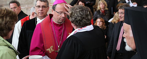 Tauferneuerung im ökumenischen Wallfahrts-Gottesdienst: Bischof Stephan Ackermann empfängt das Tauferinnerungszeichen von Oberkirchenrätin Barbara Rudolf