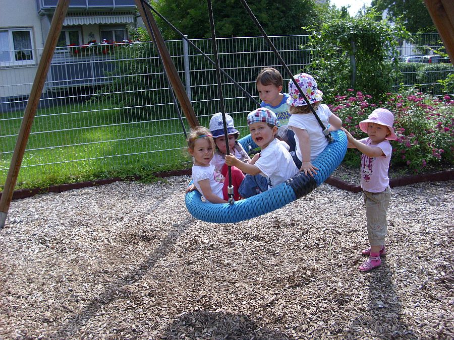 Kinder auf der Schaukel der Kita