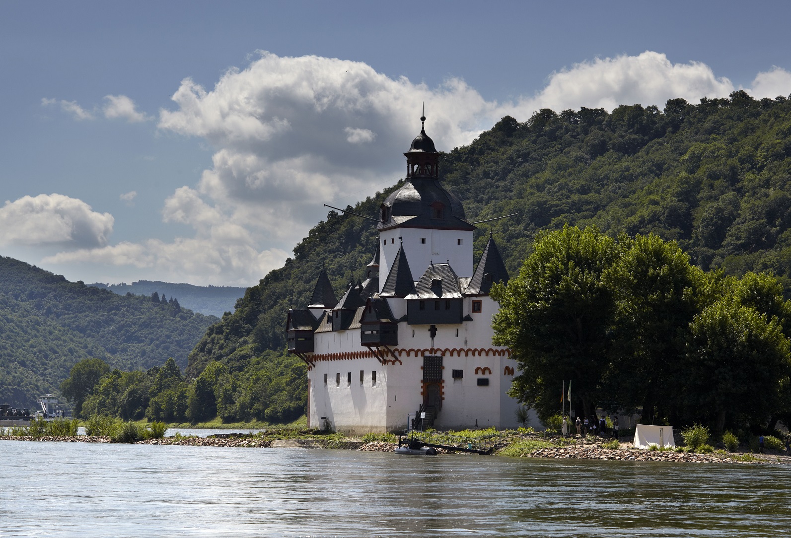 Burg, die optisch einem Schiff ähnelt und auf einer kleinen Insel inmitten eines Flusses steht