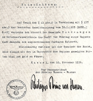 Mit diesem Schreiben des Oberpräsidenten der Provinz Hessen-Nassau, Prinz Philipp von Hessen vom 10. November 1936 wurde der Gemeinde Hundsangen das Führen eines Wappens und einer Flagge genehmigt.