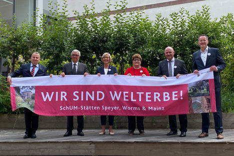 Repräsentantinnen und Repräsentanten der SchUM-Städte mit Banner.