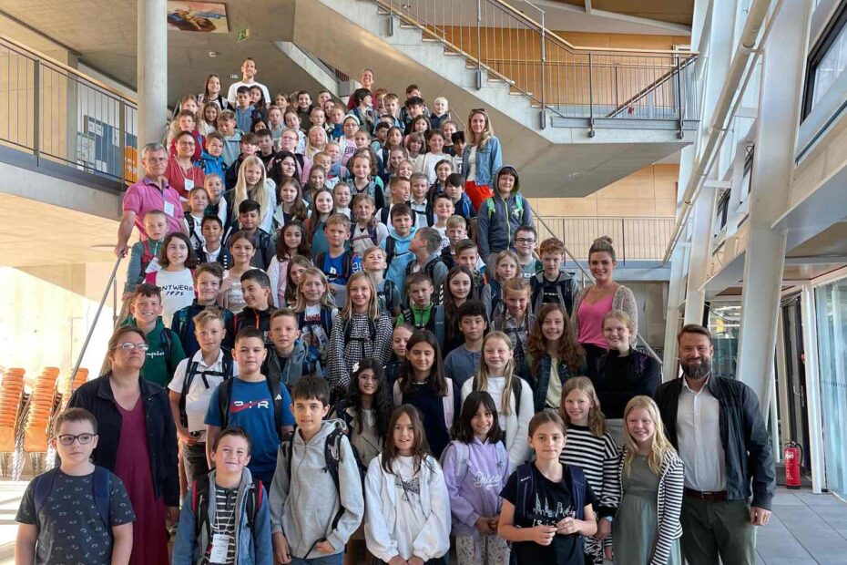 Die neuen Schülerinnen und Schüler stehen zusammen mit ihren Lehrern auf der Treppe im Foyer des PJGs.