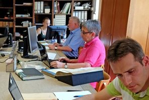 Nutzer/innen sitzen mit Laptops und Archivalien am großen Tisch. © Stadtarchiv Mainz