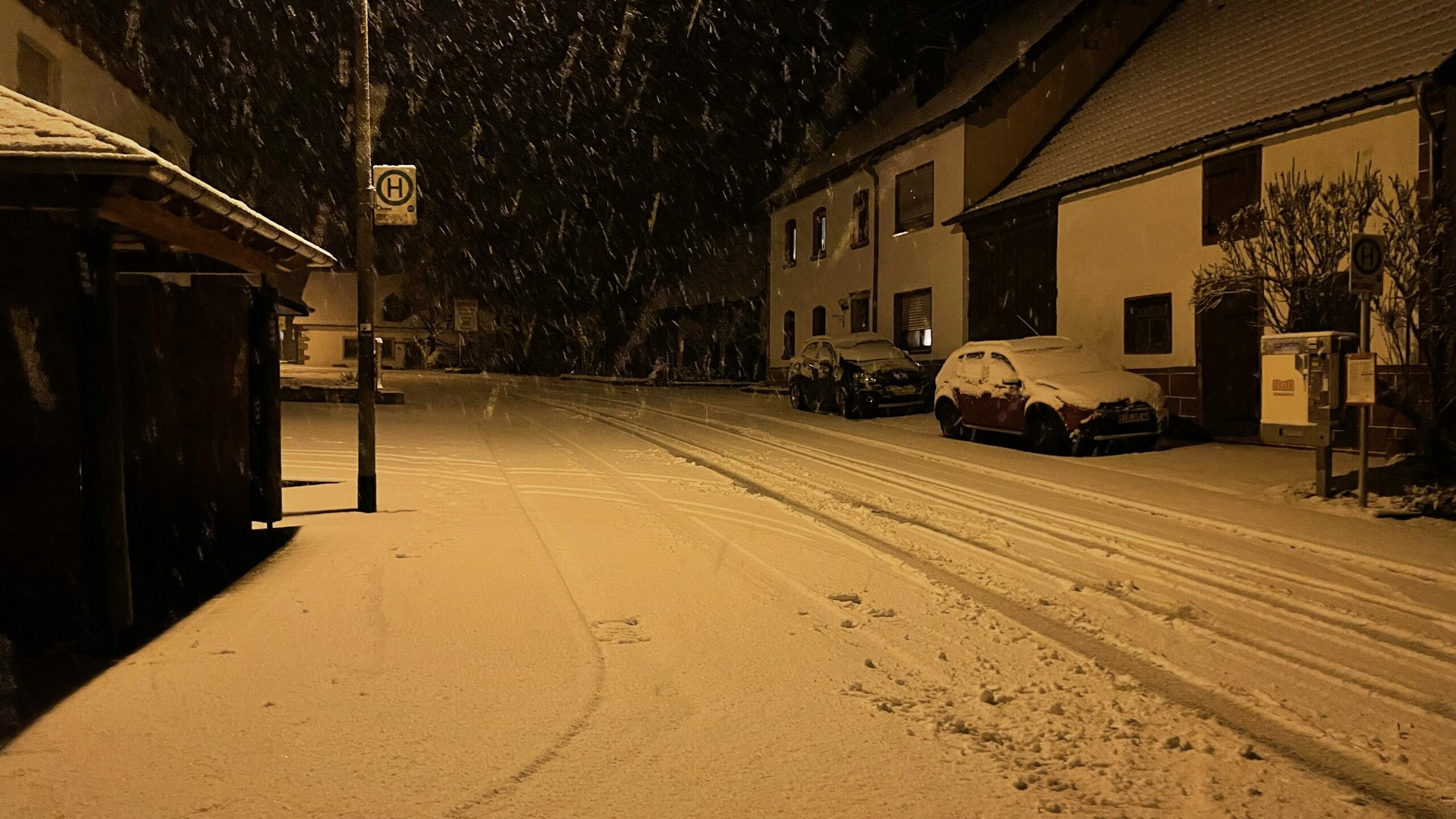 Schnee in der Hauptstraße an der Bushaltestelle.