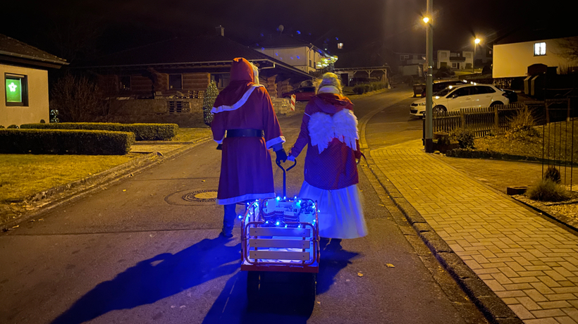 Weihnachtsmann und Christkind auf dem Weg durch die Gemeinde.