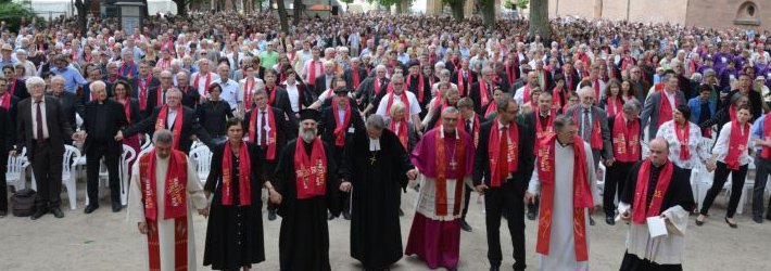 Vertreter von neun Mitgliedskirchen der ACK-Südwest feiern mit 4.000 Gläubigen den Abschlussgottesdienst des Ökumenischen Kirchentags 2015 in Speyer. Alle Mitfeiernden reichen sich zum Gebet die Hände