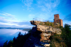 Hoch auf dem Felsenriff steht sie da, dreifach ist der rostrote Buntsandstein gespalten, daher wohl ihr Name „Trifels“.