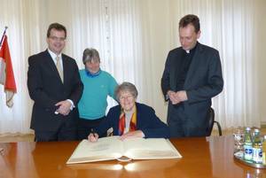 Sr. Dr. Lea Ackermann trägt sich ins Goldene Buch der Stadt ein, in Anwesenheit von Chris-tian Lange, Brunhilde Schierl und Weihbischof Herwig Gössl (v.l.)          Foto: Bärbel Meister