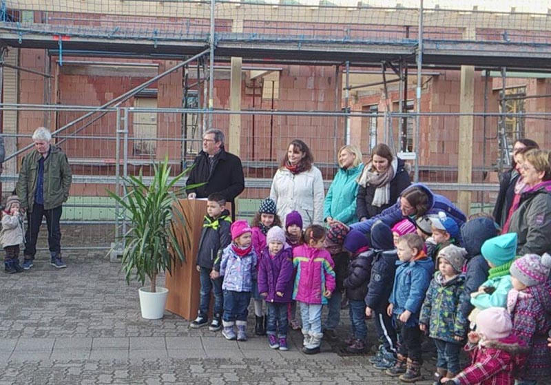 OB Eger am Rednerpult umringt von Kindern und Erziehern der Kita Pusteblume, © Stadt Speyer