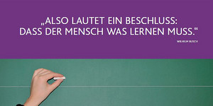 Schultafel mit einer Hand die mit Kreide schreiben möchte. Das Zitat, von Wilhelm Busch: "Also lautet ein Beschluss, dass der Mensch was lernen muss", wird zitiert. 